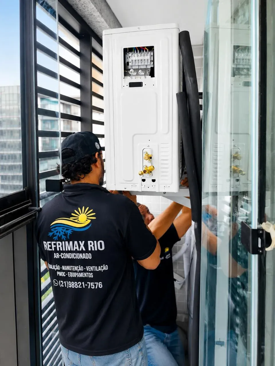 Técnico da Refrimax instalando ar-condicionado em área técnica de apartamento